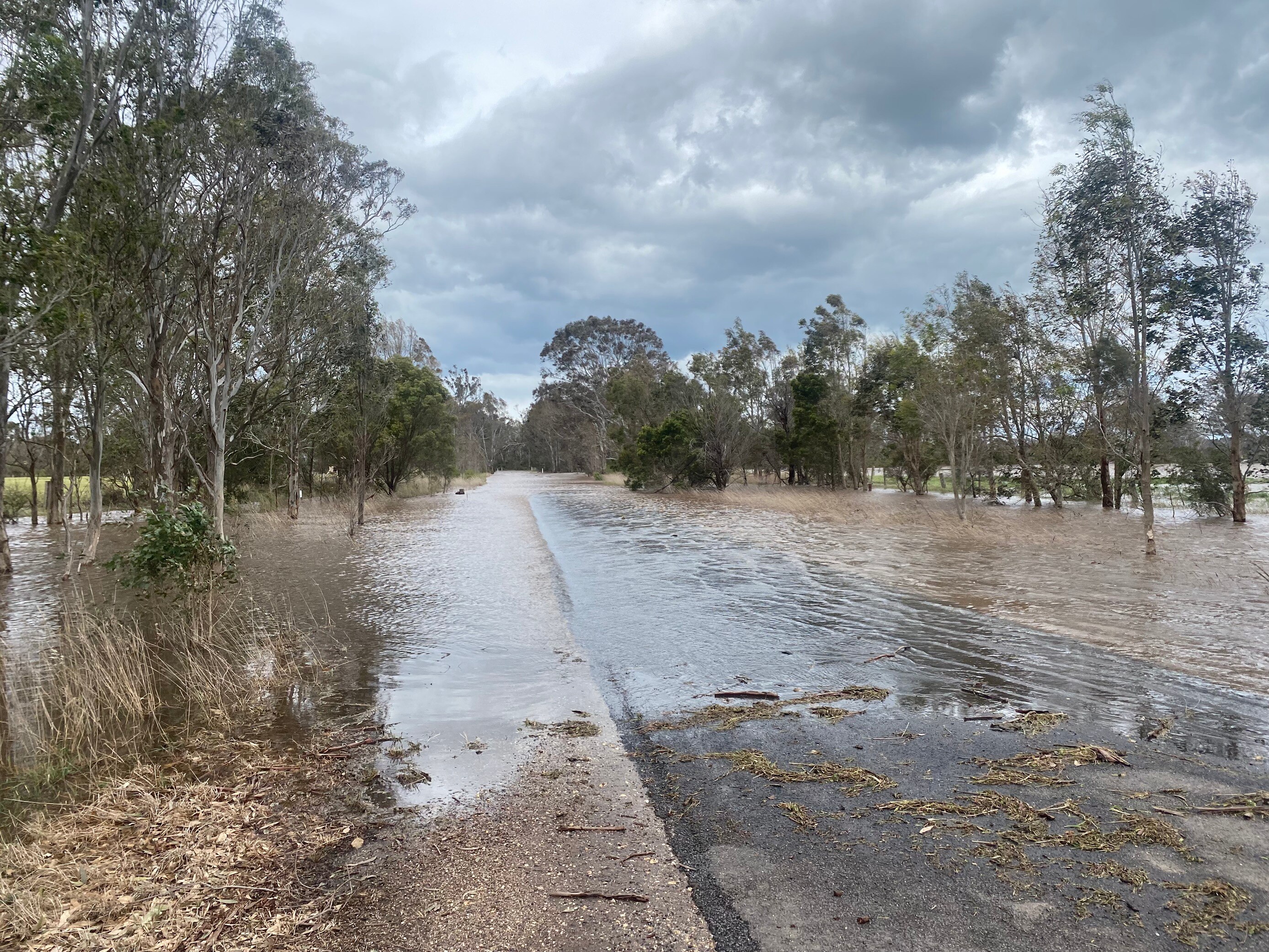 A country road covered in floodwater.
