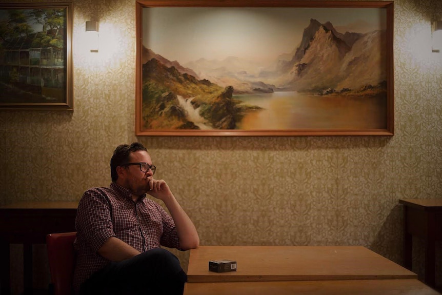 Australian journalist and author Rick Morton sits at a retro diner table.