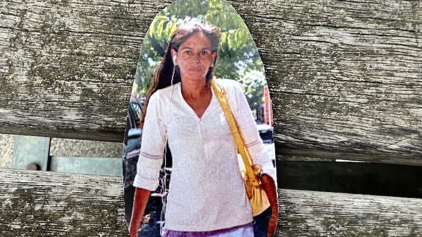Veronica Nelson in a cut-out photograph, wearing a white shirt and yellow handbag.