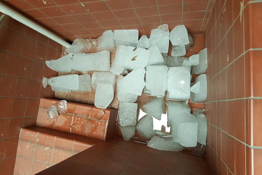 Photograph of large blocks of ice melting in the bottom of a mikvah