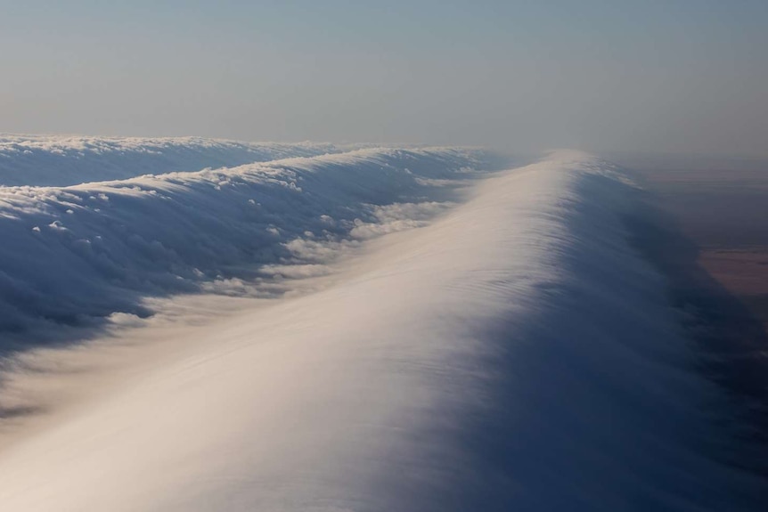 Clouds that look like waves high above the ground.