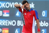 Novak Djokovic wipes sweat from his brow.