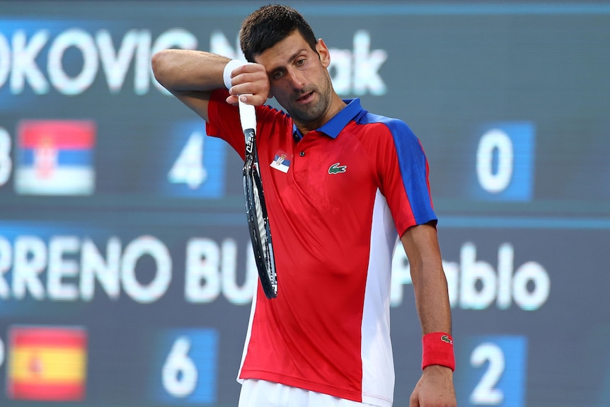 Novak Djokovic wipes sweat from his brow.