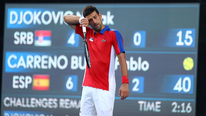 Novak Djokovic wipes sweat from his brow.