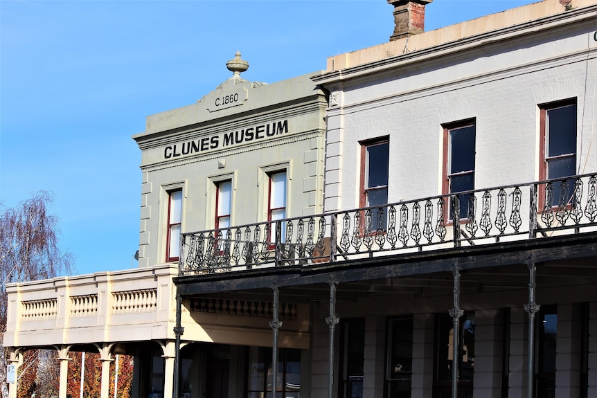 The outside of a top level of a historic building with the name Clunes Museum written in black bold letters