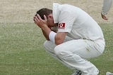 Peter Siddle (c) sinks to his knees while team-mates Mike Hussey (r) and Ben Hilfenhaus console him.