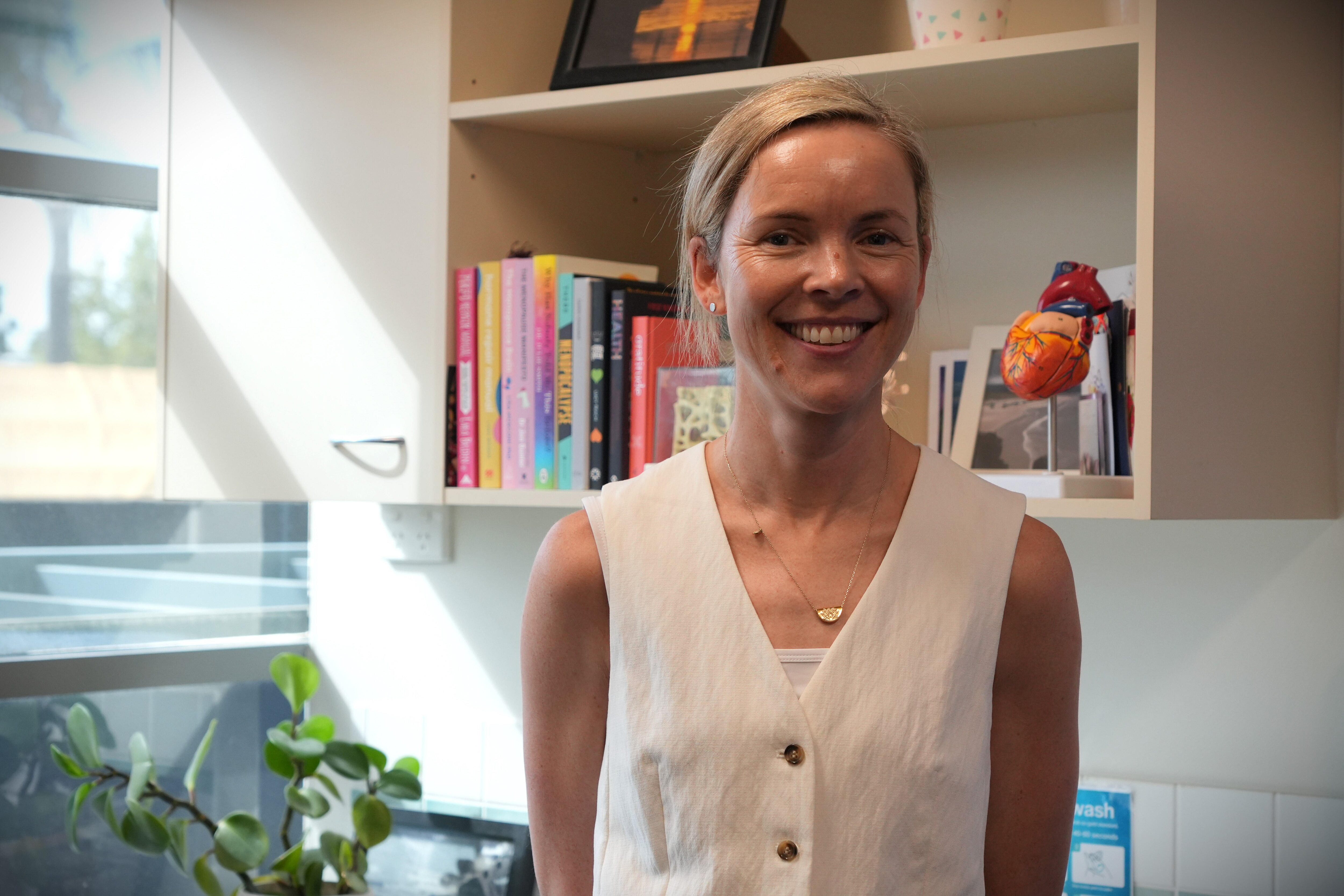 Dr Niamh Leonard stands in her office wearing a shite vest and black pants.