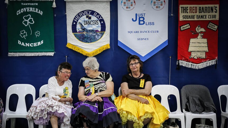 Women square dancers sitting on sidelines