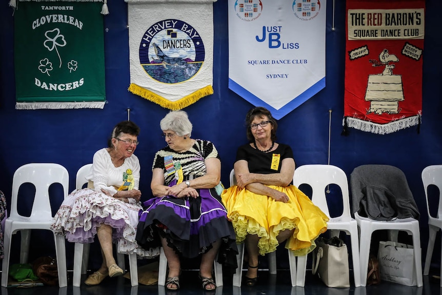 Women square dancers sitting on sidelines