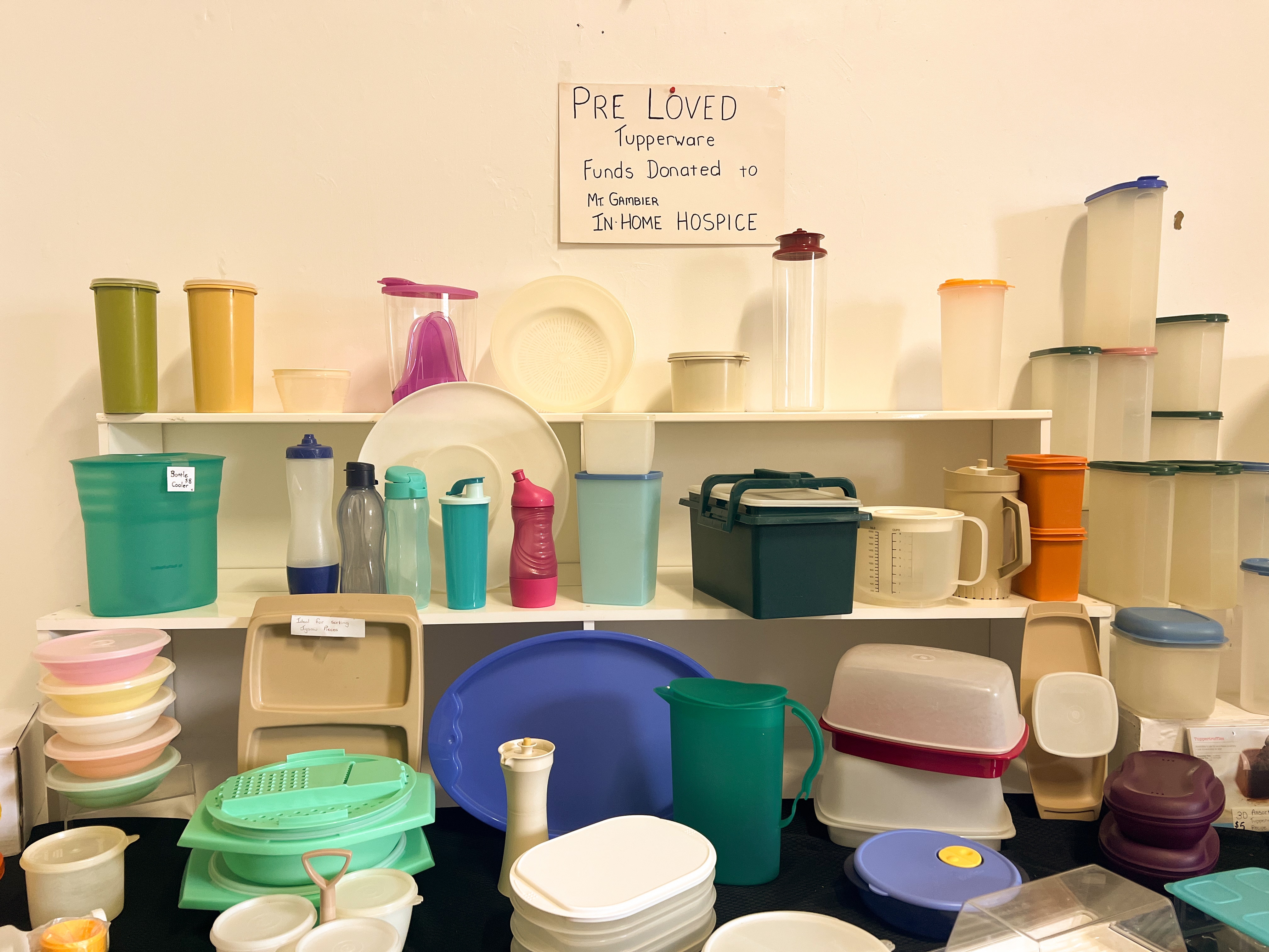 Plásticos coloridos nas prateleiras com uma placa de amado.