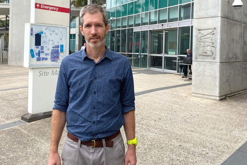 A doctor standing outside a hospital emergency department