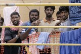 Four Sri Lankan asylum seekers look out from the Oceanic Viking on October 27, 2009.
