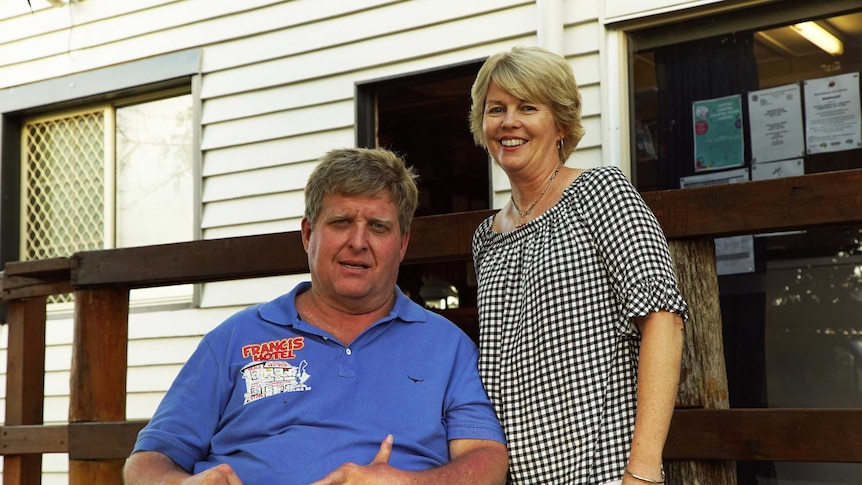 A couple in outback Australia smile in a portrait.