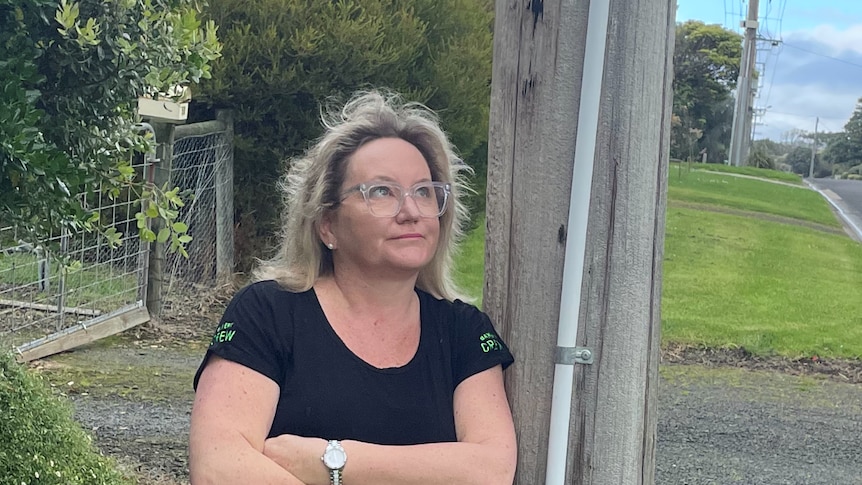 Sally Cannon, co-owner of the Apollo Bay Bakery, looks up at a power pole near her house