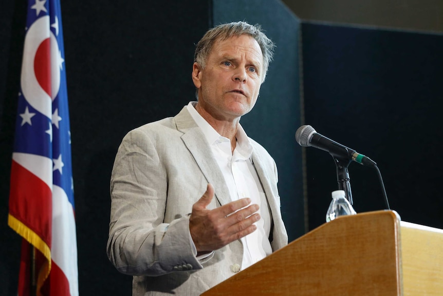 Fred Warmbier stands at a lectern and speaks during a news conference.