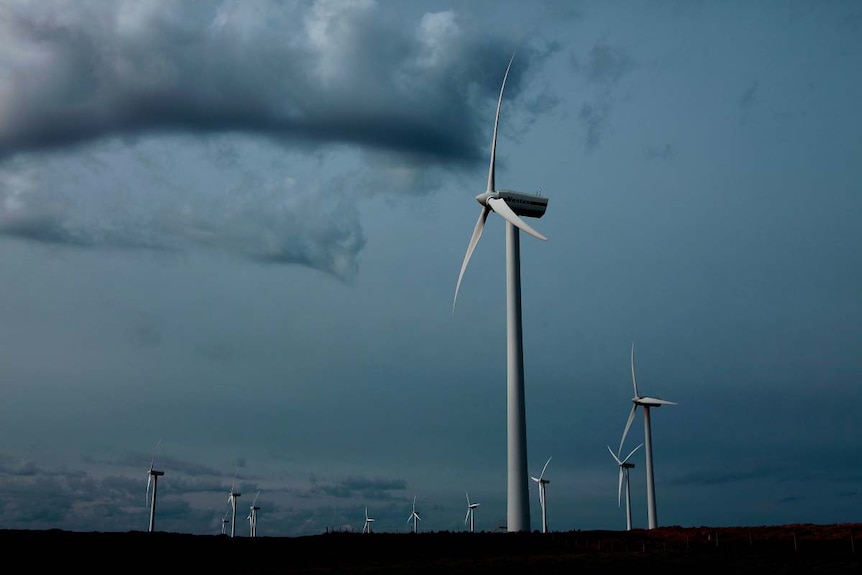 Grey clouds provide a background for a field of wind turbines in north-west Tasmania.