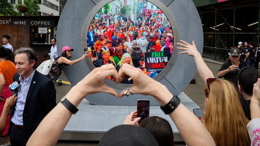 A person's arms are pictured shaping a heart with its hands, behind it a large round portal in which people in Dublin are seen
