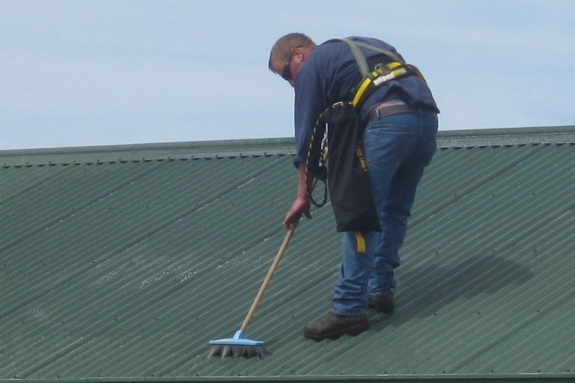 Worker scrubbing roof in Esperance lead clean up.
