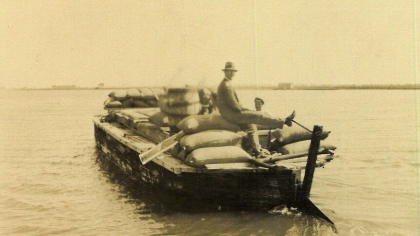 An archival photo of bags of wool transported by boat.