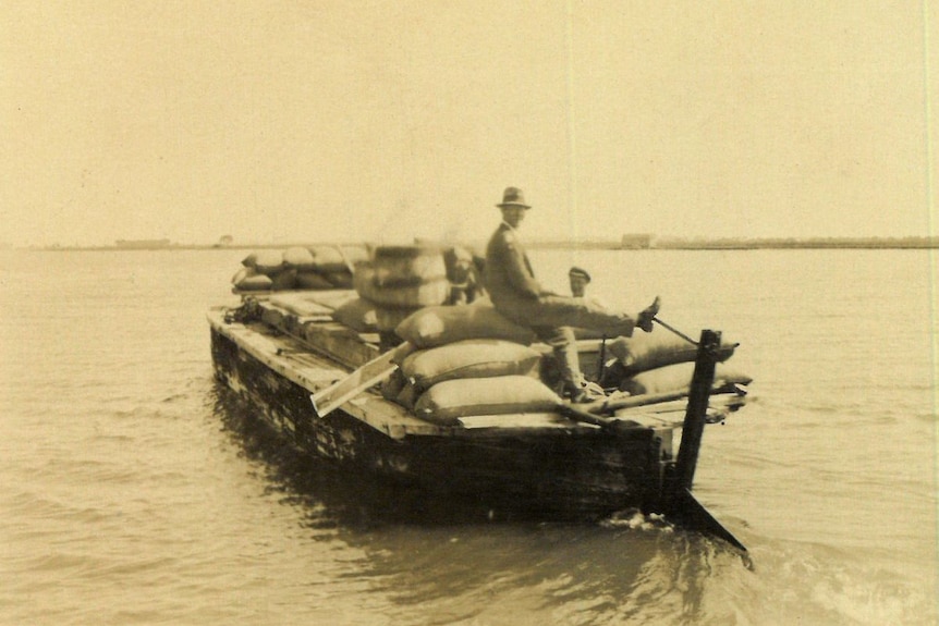 An archival photo of bags of wool transported by boat.
