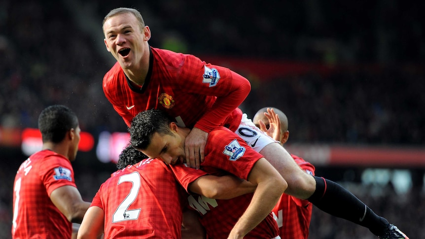 Table toppers ... Robin van Persie is flanked by his Red Devils team-mates after scoring against Arsenal