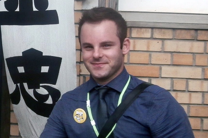 A head and shoulder shot of Mathew Reale smiling and wearing a blue shirt and tie.