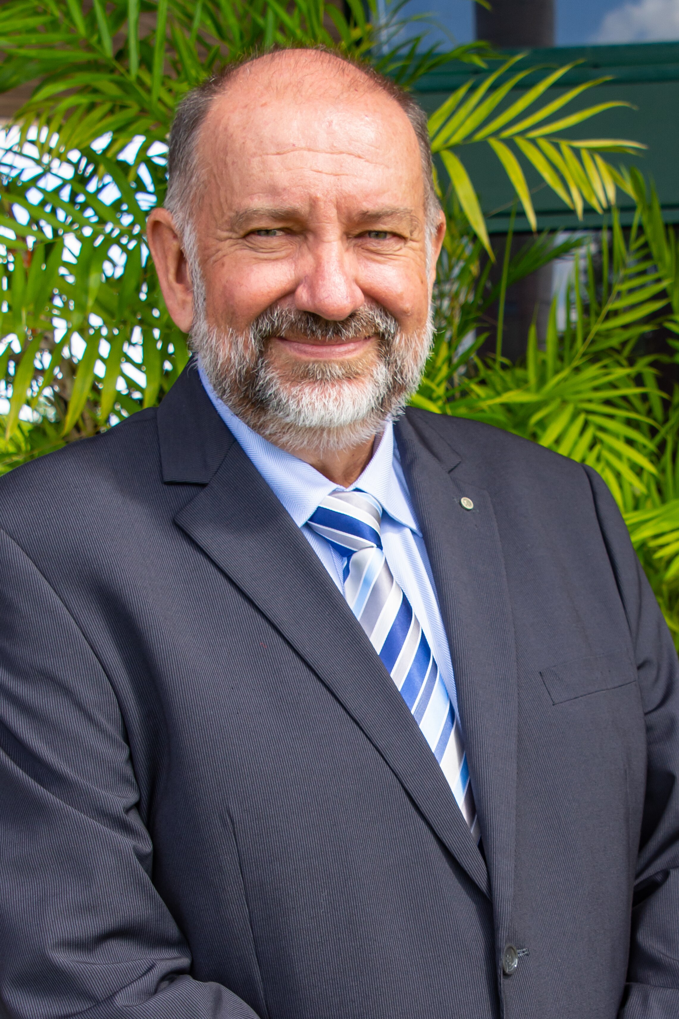 Deputy Mayor Graham Lohmann smiles at camera wearing black suit