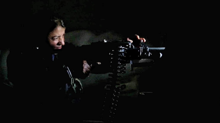 A female commander fires a weapon in Aleppo