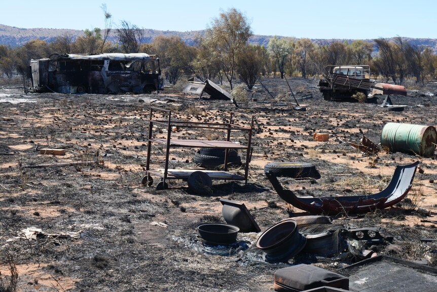 Burnt-out bus, cars and shrubs litter the scorched landscape.
