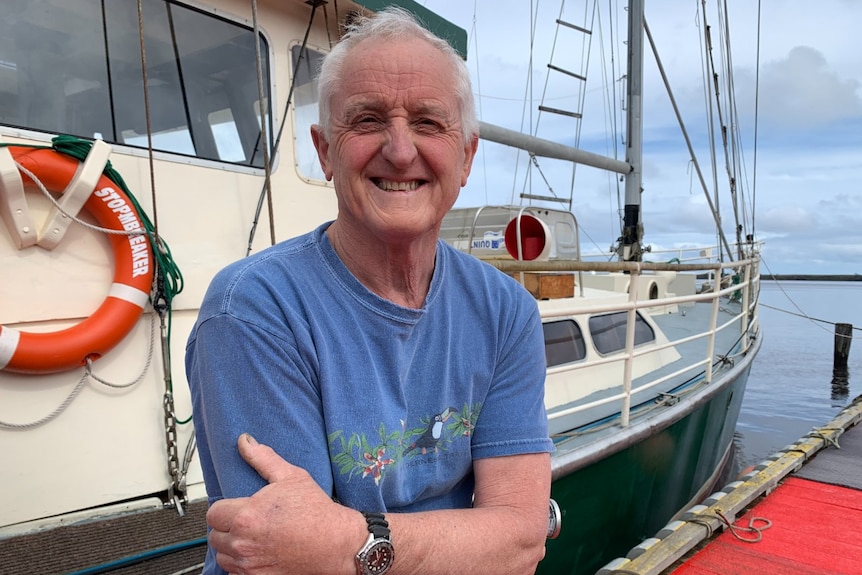 A man stands in front of a charter boat