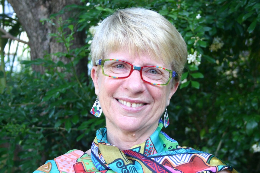 Profile photo of Dr Linda Gilmore standing outside in front of greenery.