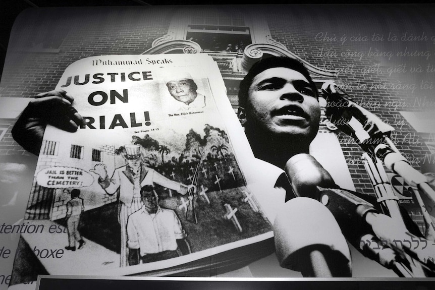 Muhammad Ali holding up a 'Justice on Trial' sign