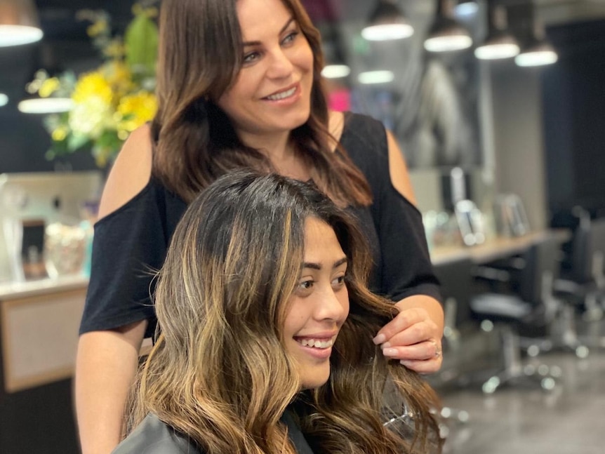 a female hairdresser standing behind a woman in a salon