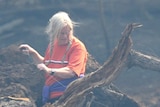 Local resident Vivienne Whitehurst attempts to fix her fence after a fast moving bushfire reached the outskirts of Kilmore, north of Melbourne, on Tuesday February 11, 2014