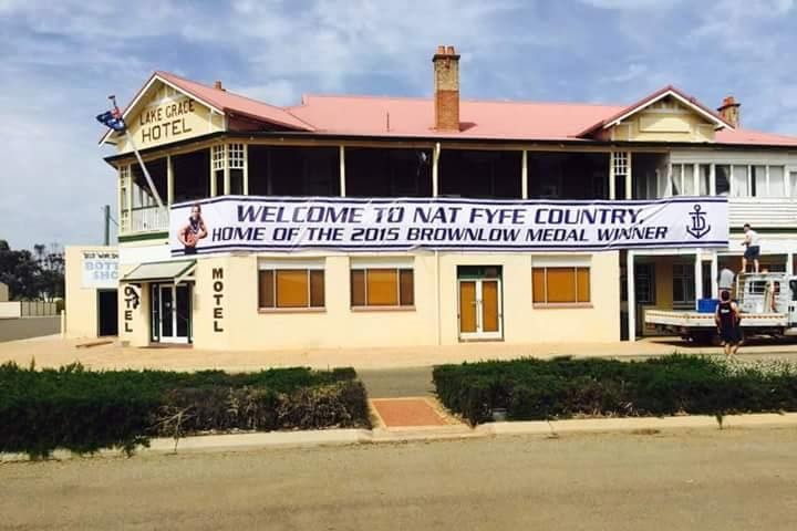 A small town pub with a huge banner hanging outside.