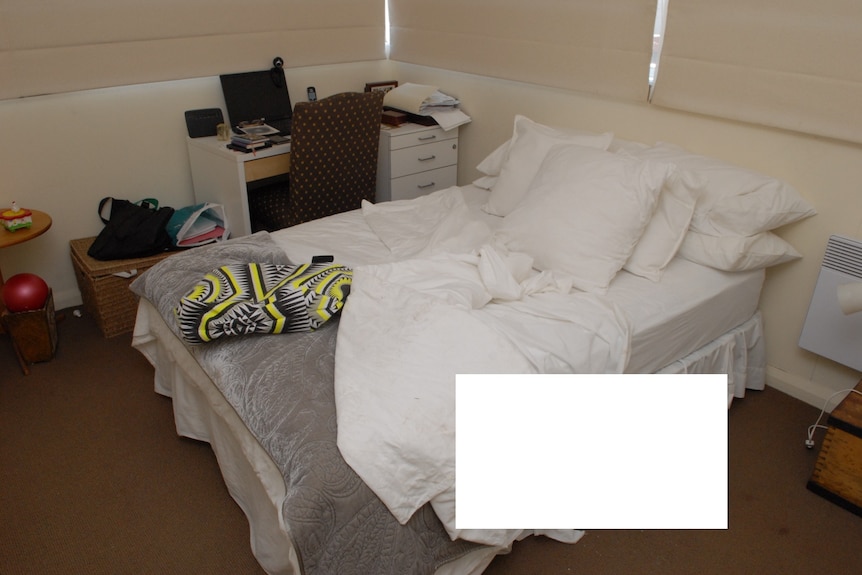An unmade bed, with an area blocked out.
