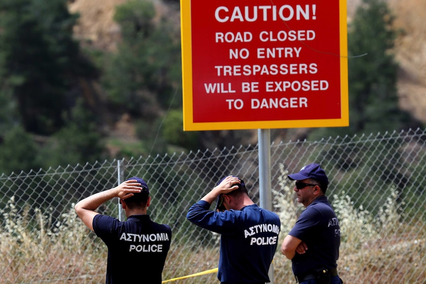 Police officers stand by the man made lake near village of Mitsero outside of the Cypriot capital Nicosia
