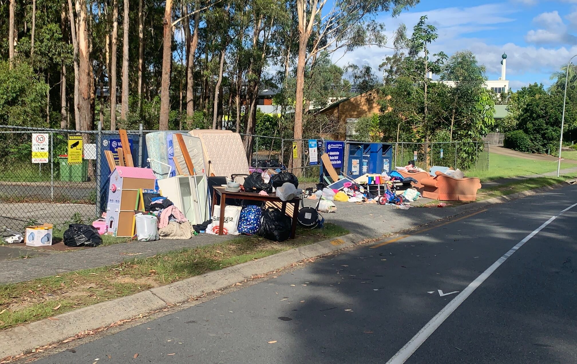 Dumped furniture and rubbish on footpath.