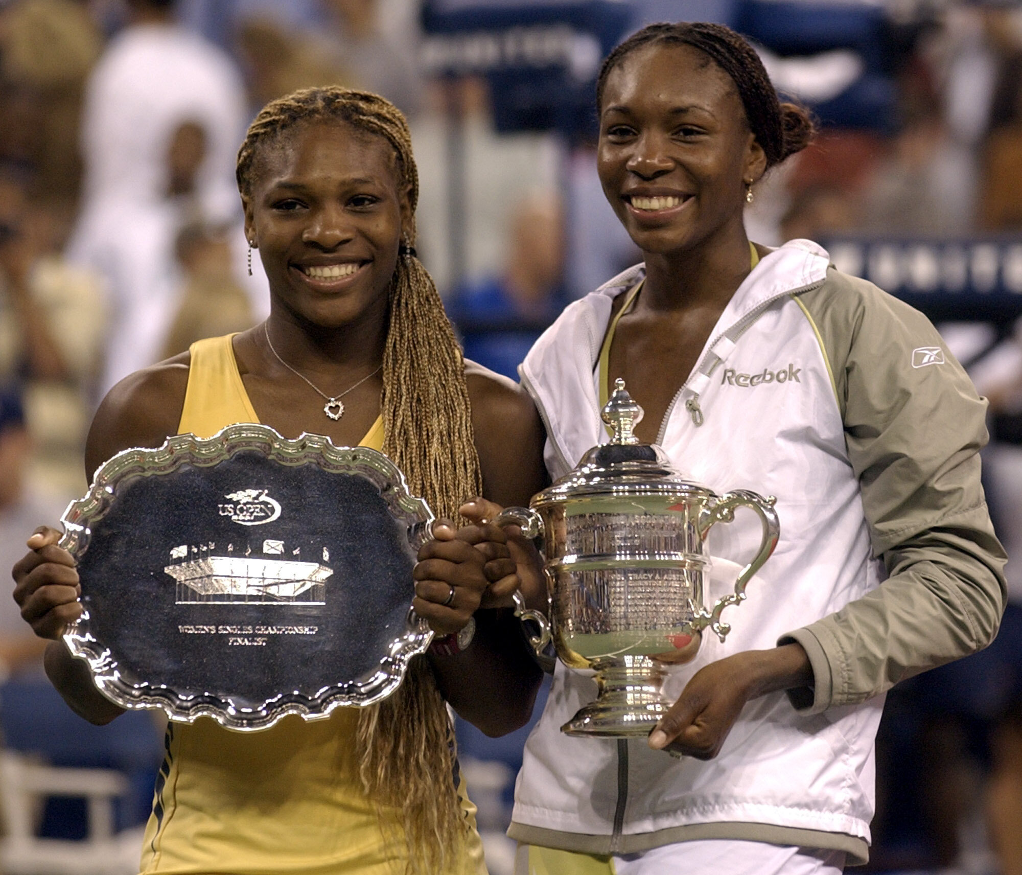 Venus y Serena Williams sostienen sus trofeos de la final del US Open de 2001.
