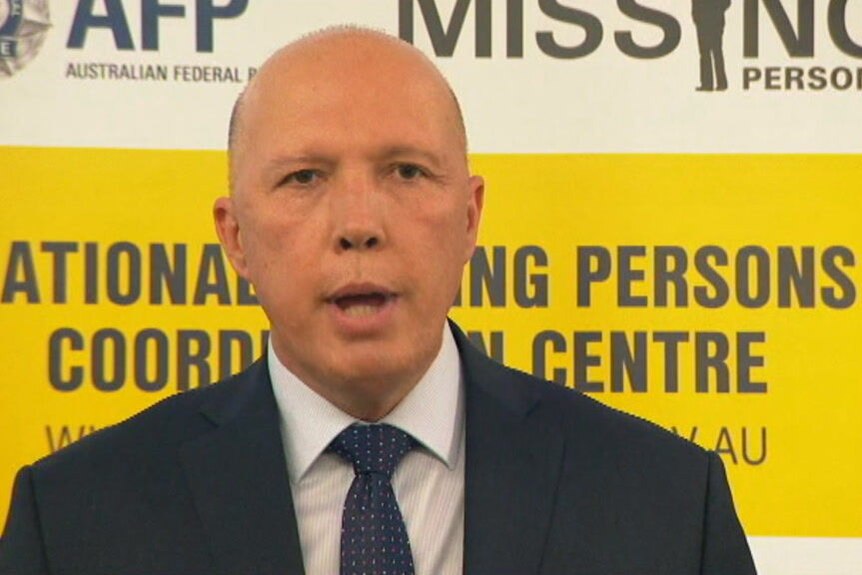 Peter Dutton speaks in front of a yellow and white background.