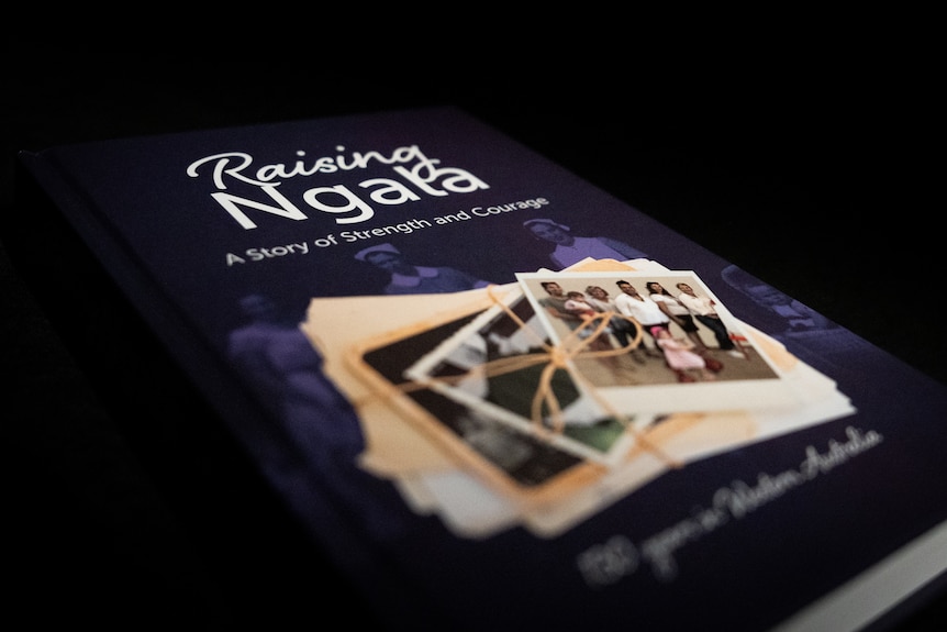 A book with a purple cover titled Raising Ngala.