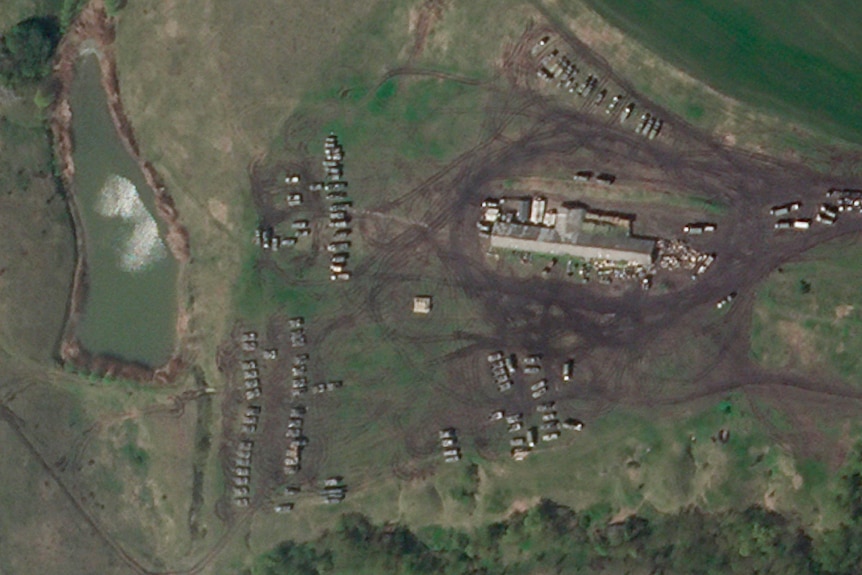 A satellite image appears to show dozens of parked tanks and armored vehicles