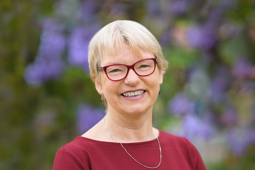 Greens Senator for Victoria Janet Rice smiles in front of a garden
