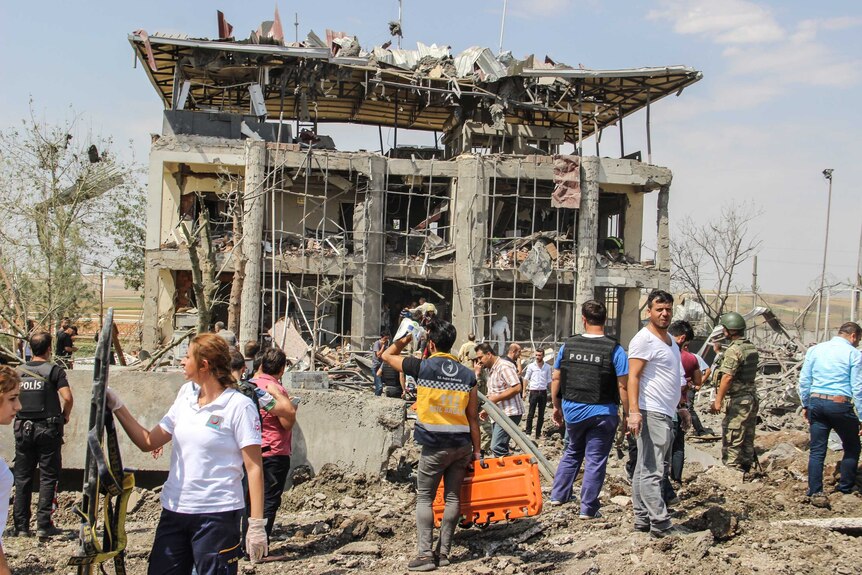 Police officers and rescue personnel outside the destroyed police station