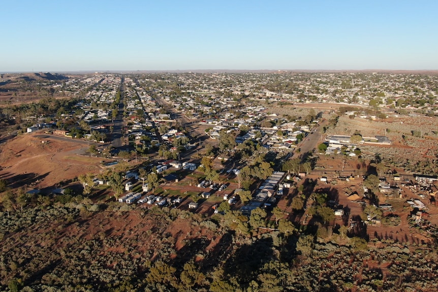 Aerial view of flat outback city of Broken Hill, looking up the main street and flat land all around, with the big mine mound 