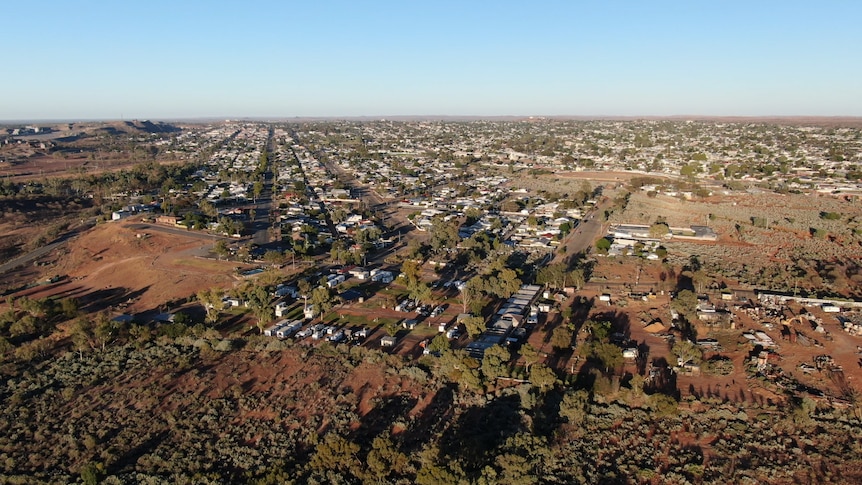 Aerial view of flat outback city of Broken Hill, looking up the main street and flat land all around, with the big mine mound 