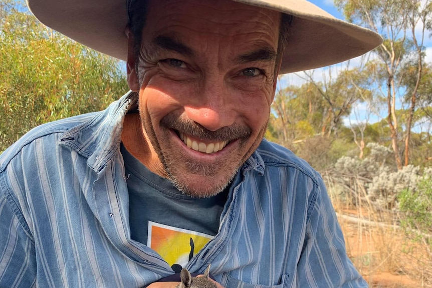 A man holding a numbat.