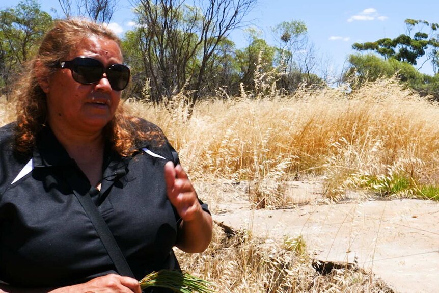 An Indigenous woman stands outside the Littlewell-Mingenew Aboriginal Reserve