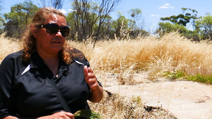 An Indigenous woman stands outside the Littlewell-Mingenew Aboriginal Reserve