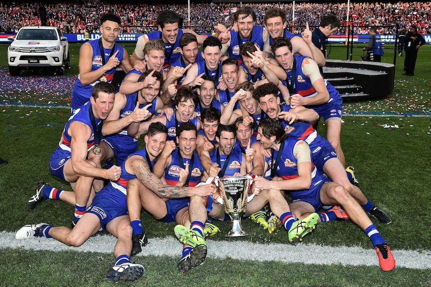 The Western Bulldogs celebrate with the premiership trophy after winning the AFL grand final